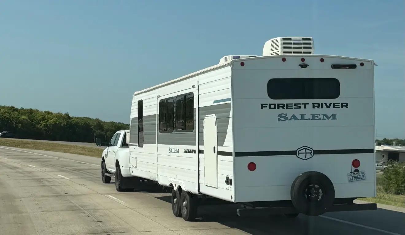 A travel trailer being towed down the highway on its way to a delivery
